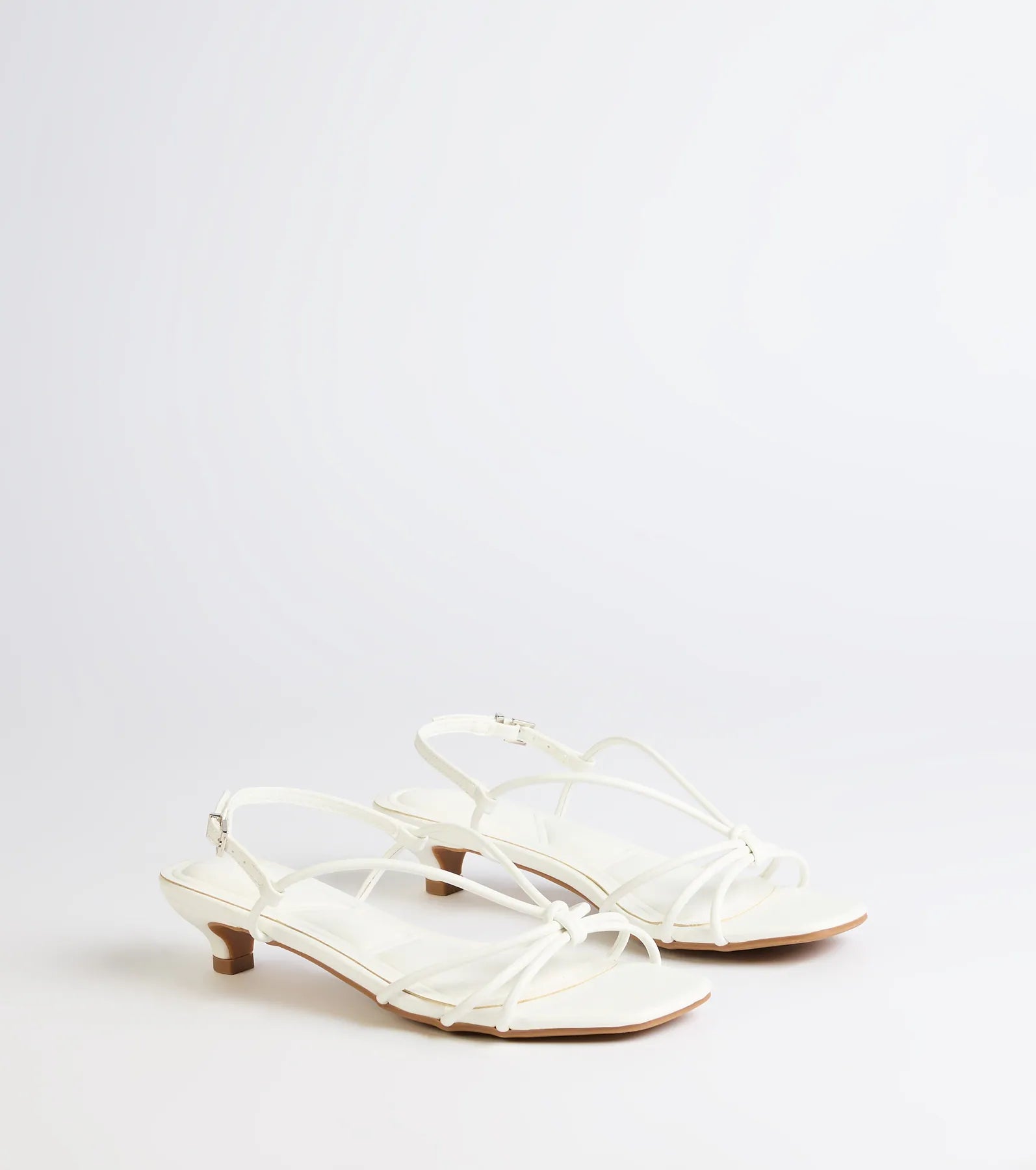 Style made simple with the Tied Together Strappy Kitten Heels in white, trendy women’s shoes that take your outfit from basic to bold in one step.
